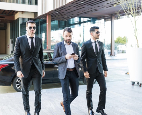 Front view of a man being escorted safely by two members of security