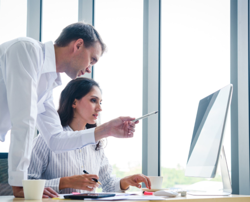 Senior businessman give advise to another businesswoman on a serious project in office
