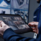 Hands close up shot of security operator zooming and monitoring CCTV cameras using tablet