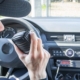 Security guard in patrol car using walkie-talkie