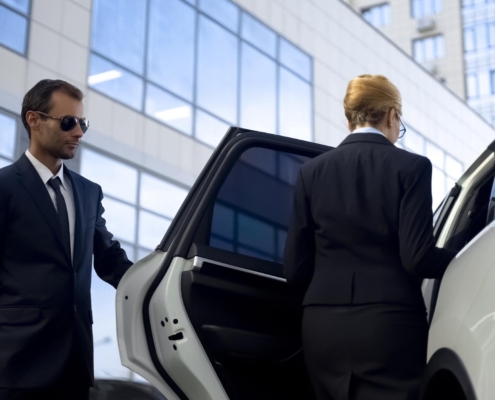 Security guard opening car door for high-profile person