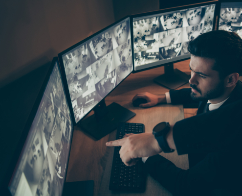 Side view of man in suit observing CCTV footage with serious face