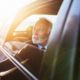 Senior business man sitting in his limousine. Business concept. Back light.