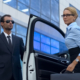 Bodyguard in suit opening car door to female boss