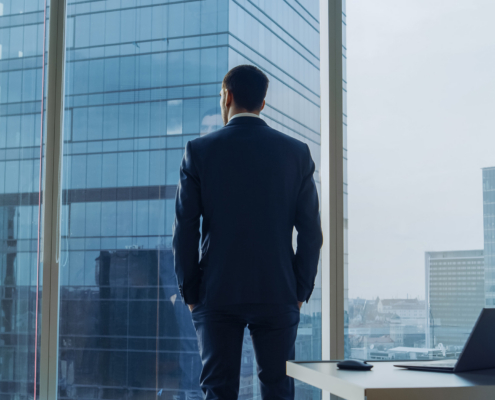 Thoughtful Businessman wearing a Suit Standing in His Office