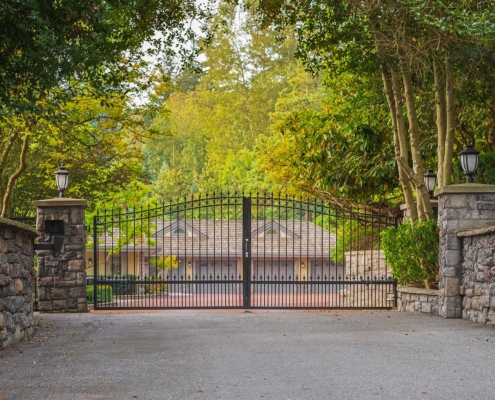 Estate security gate in front of house